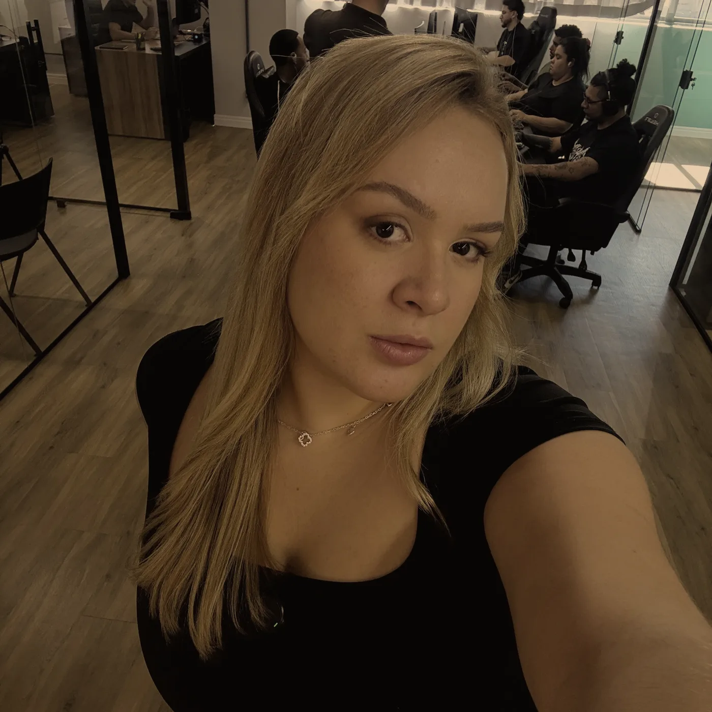 Julia Mel Prado no escritório da Sobcom, com a equipe trabalhando ao fundo